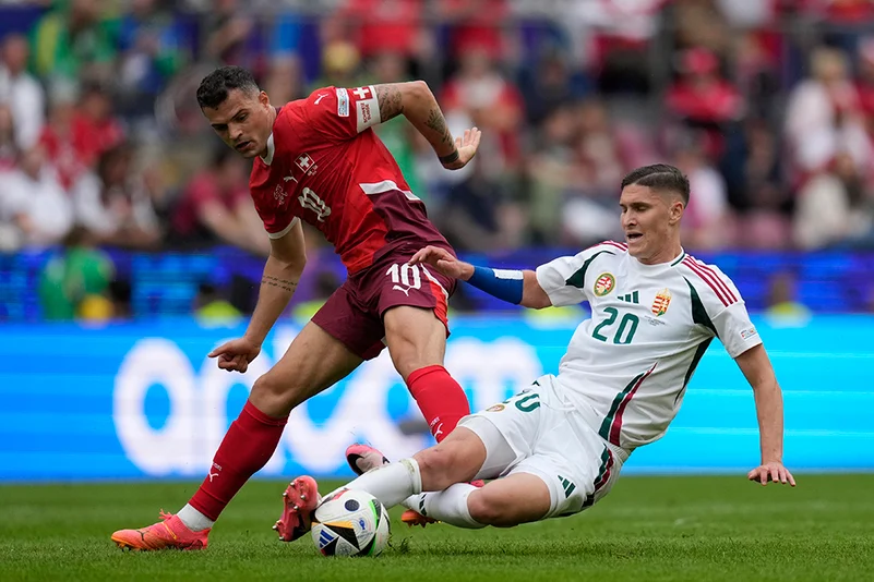 Granit Xhaka challenges for the ball with Roland Sallai